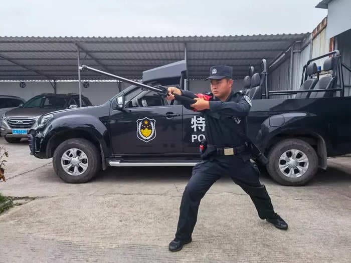 A police officer brought an 'electro-sword' to stand guard outside an exam center as Chinese students took the tests of their lives