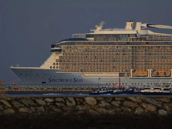 A search is underway for a passenger who fell off a Royal Caribbean ship in Singapore. 'My mother could not swim,' the passenger's son said.