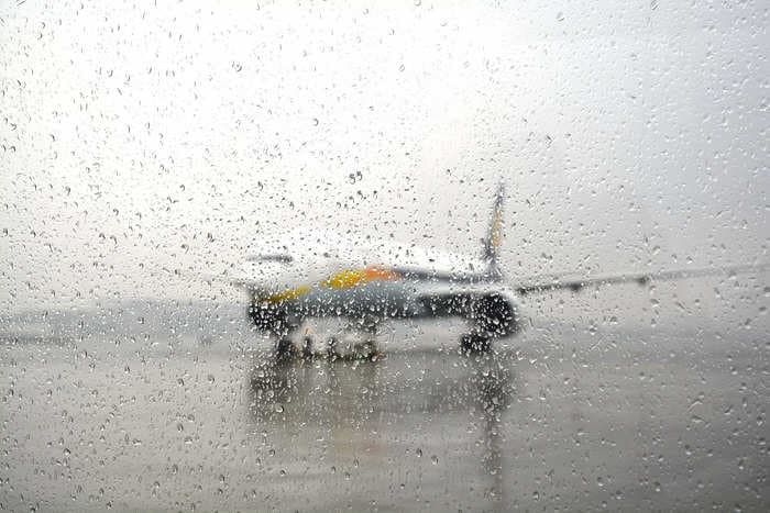 Delta is getting flak after a passenger posted a video of her seat and bag getting soaked by a torrent of rain pouring through an open plane door