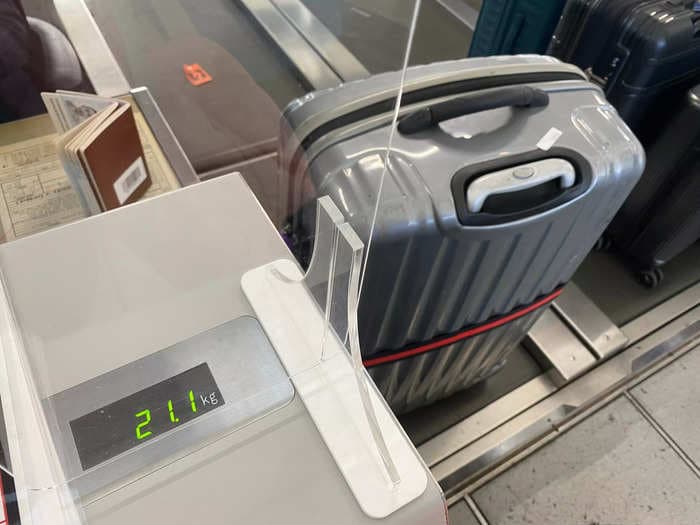 A travel hack where people stick their feet under luggage scales to try to get their bags under the weight limit is dividing TikTok