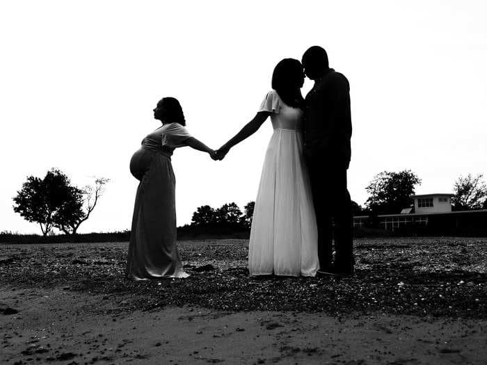 A photographer captured an emotional moment between a surrogate and the intended mom holding hands