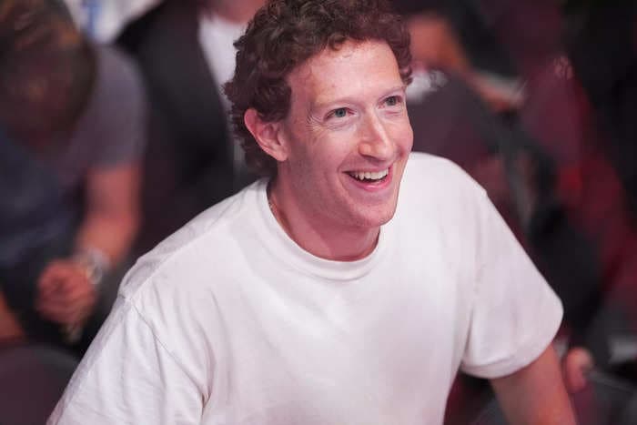 Mark Zuckerberg wishes America a happy birthday while surfing in a suit with beer and flag in hand
