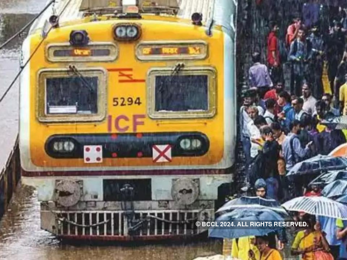 Passengers walk on railway tracks after bamboo structure falls on overhead wire, hits Mumbai local train services