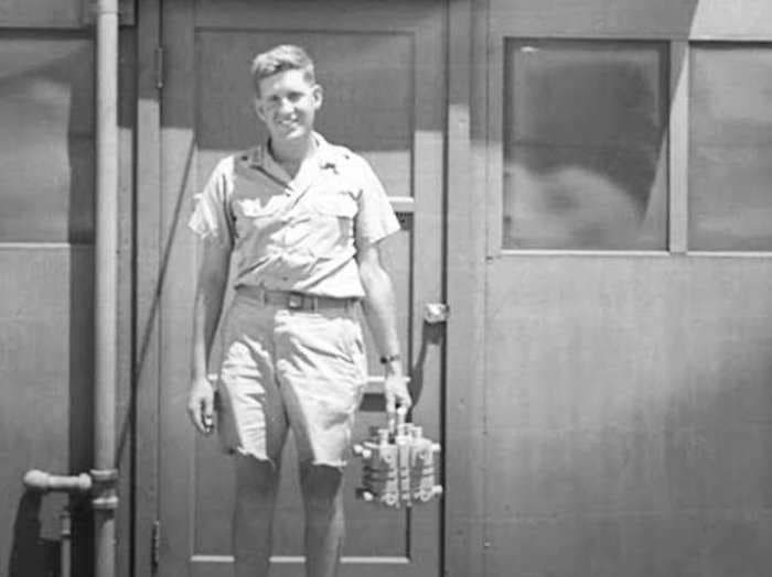 An unsettling picture of a US physicist cheerfully holding the 'Fat Man' atomic bomb's core