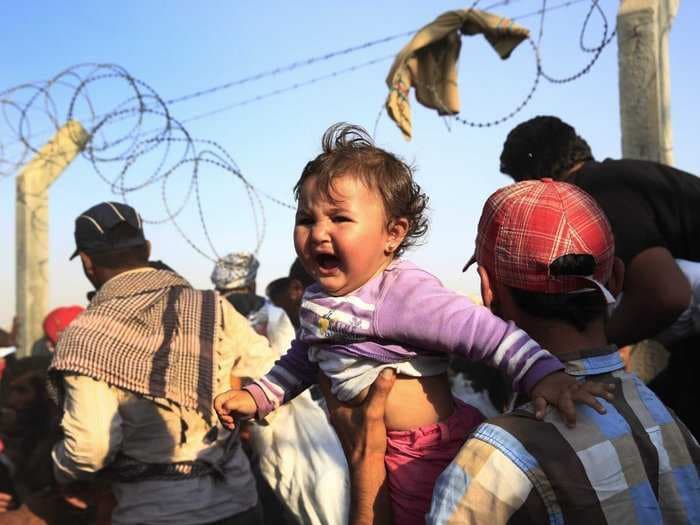 Children are crawling through barbed wire on Turkey's border to flee ISIS