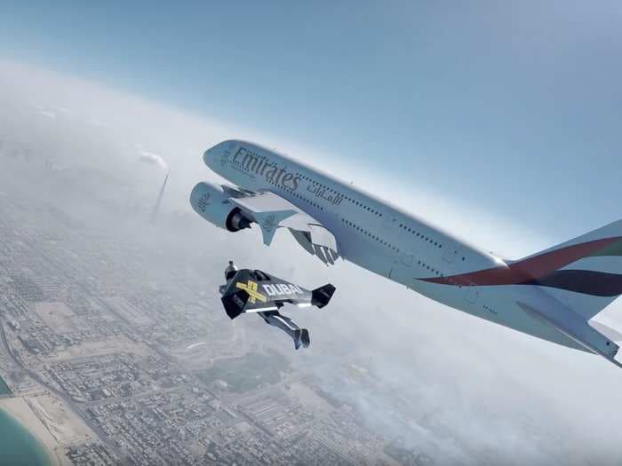 Watch 2 guys with jetpacks weave around an airplane in the Dubai sky