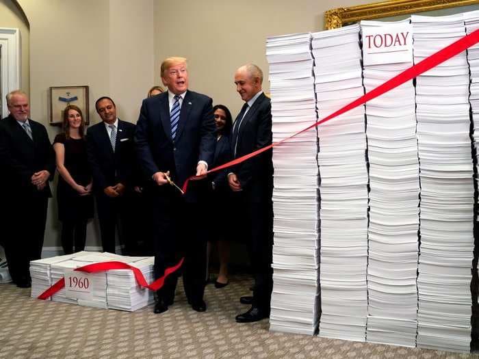 Trump cut literal red tape while standing next to a massive pile of paper to make a point about big government