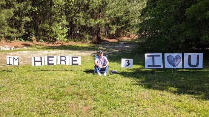 A husband sat outside a hospital window for hours with signs telling his wife he loved her as she underwent chemo