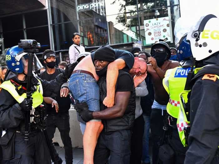 This powerful image of a Black man carrying a white counterprotester to safety frames a day of chaos and race-inspired violence in London