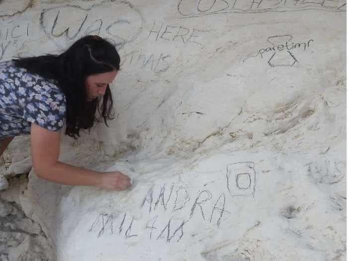 An influencer has apologized after she left graffiti on ancient chalk cliffs