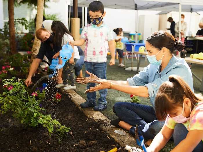 Meghan Markle wore a $60 denim shirt to plant Princess Diana's favorite flowers at a preschool in Los Angeles