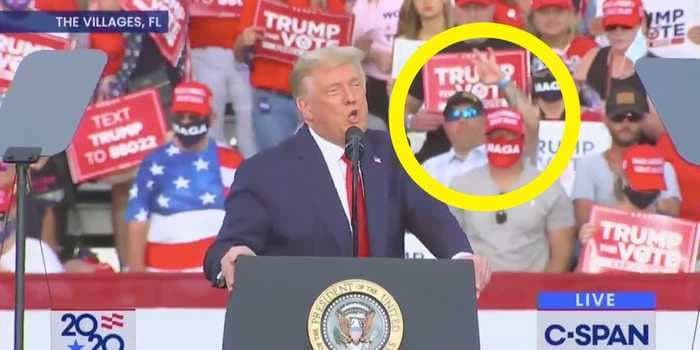 Video shows a man holding up a hand gesture tied to white supremacy behind Trump at his Florida rally