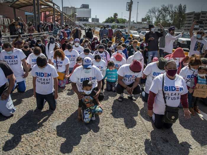Migrants waiting at the US-Mexico border have been photographed wearing shirts that say 'Biden, please let us in!'