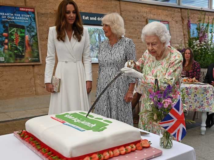 The Queen insisted on using a large ceremonial sword to cut a cake, prompting giggles from Kate Middleton