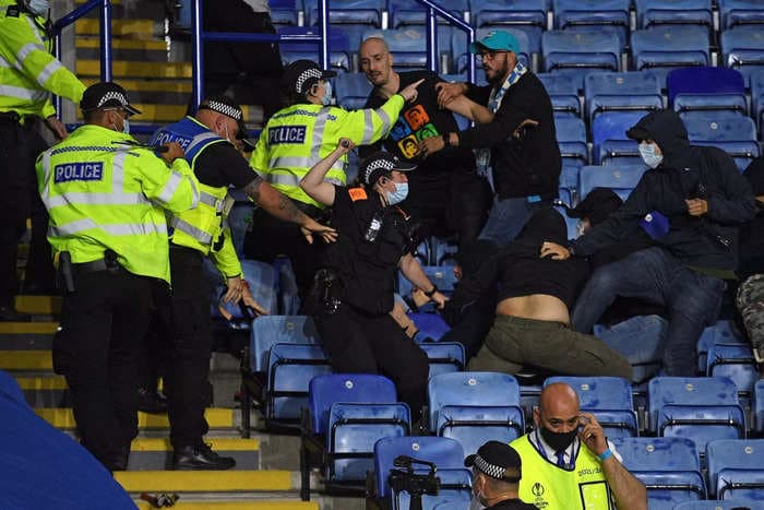 Opposing fans launched missiles, threw punches, and whipped each other with belts in a violent clash after a Europa League match
