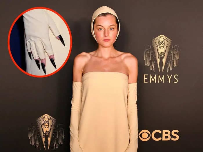 Emma Corrin stood out on the Emmys red carpet in a strapless yellow dress with a swim cap-like hat and claws