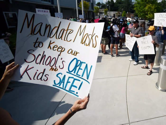 A Minnesota school board meeting devolved into chaos after an attendee grabbed another man wearing a mask