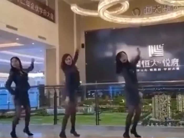 A video shows female Evergrande staff dancing to entertain clients at one of the company's property showrooms