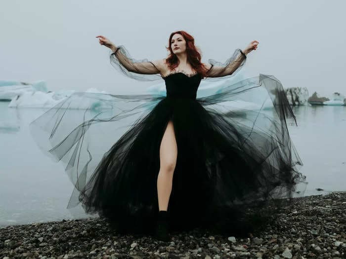 A bride wore a black wedding dress with sheer sleeves and a thigh-high slit to her Iceland elopement