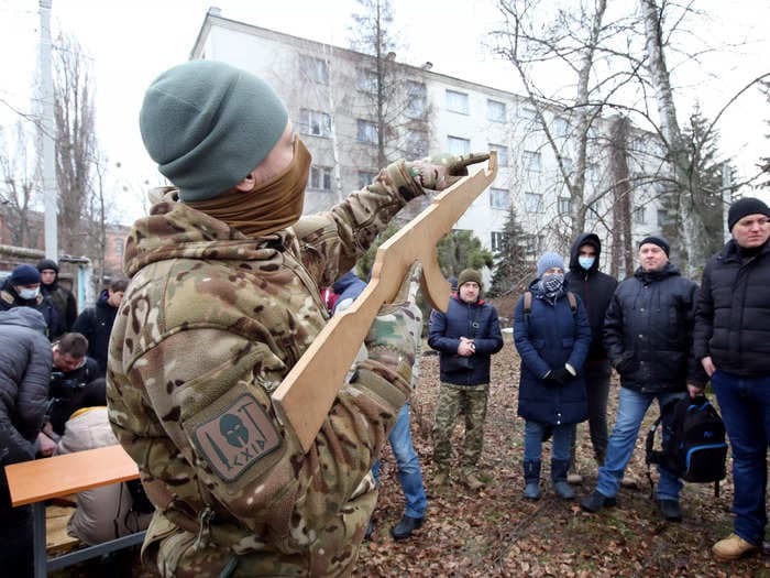 An image of Ukrainians holding wooden guns has sparked baseless claims on social media that Russia's invasion of Ukraine is staged