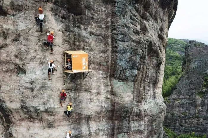 The world's 'most inconvenient' convenience store hangs on the side of a cliff in China, selling bottled water and snacks to parched climbers