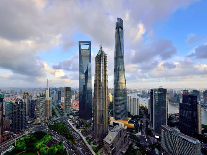A cluster of 3 towering skyscrapers, each taller than 1,300 feet, forms a distinctive peak above Shanghai's financial district — check it out
