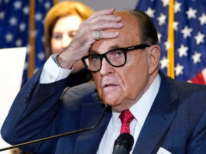 Rudy Giuliani claimed a grocery-store employee's attack on him felt like a gunshot. CCTV footage shows he was slapped on the back.