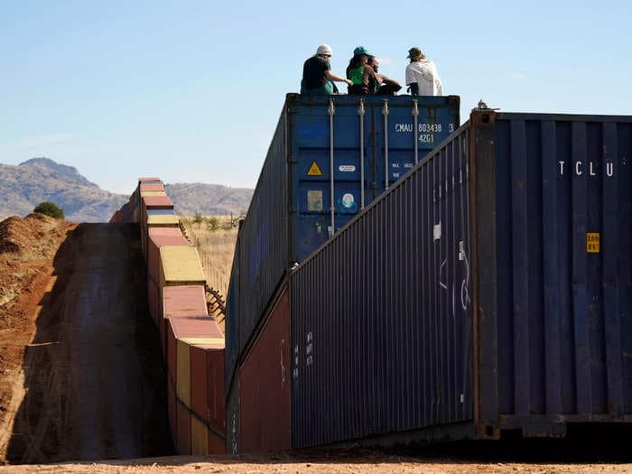 Photos show the hundreds of shipping containers stacked to form a haphazard 'border wall' between Arizona and Mexico that sparked a federal feud