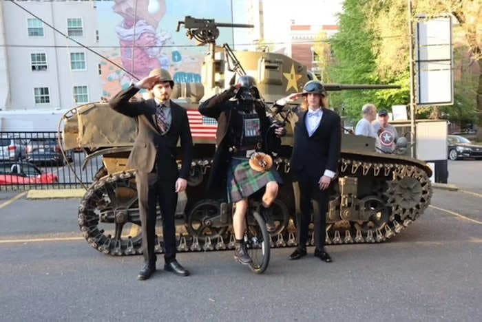 Teens take WWII-era M3A1 tank to prom, led by a bagpipe player on a unicycle wearing a Darth Vader mask