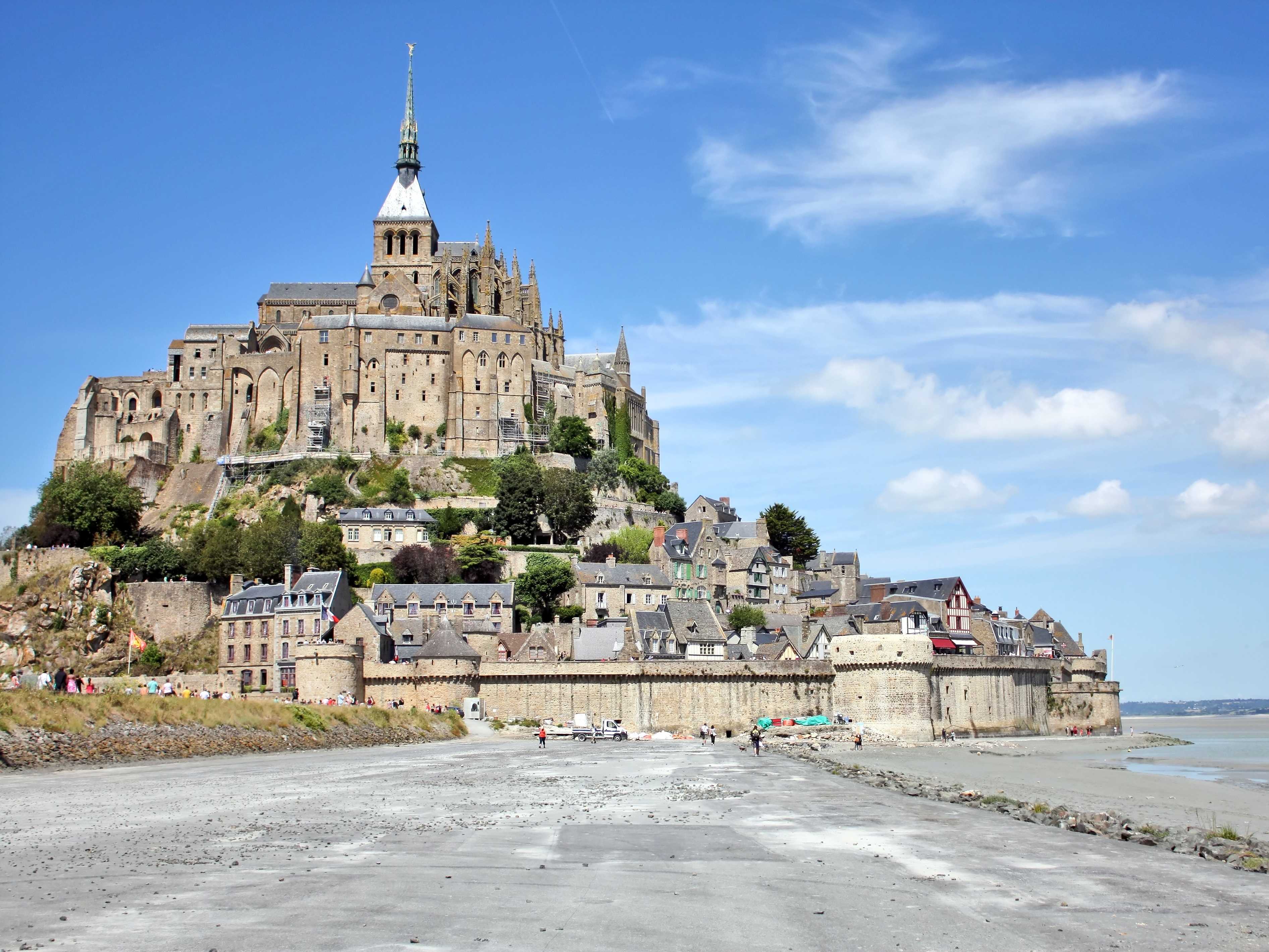 Walk along the mud flats of Mont Saint-Michel Bay during low tide and ...