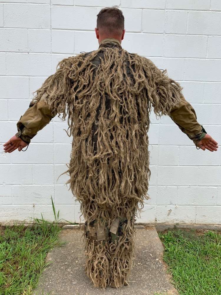 A ghillie suit, as can be seen here, is designed with loose strips ...