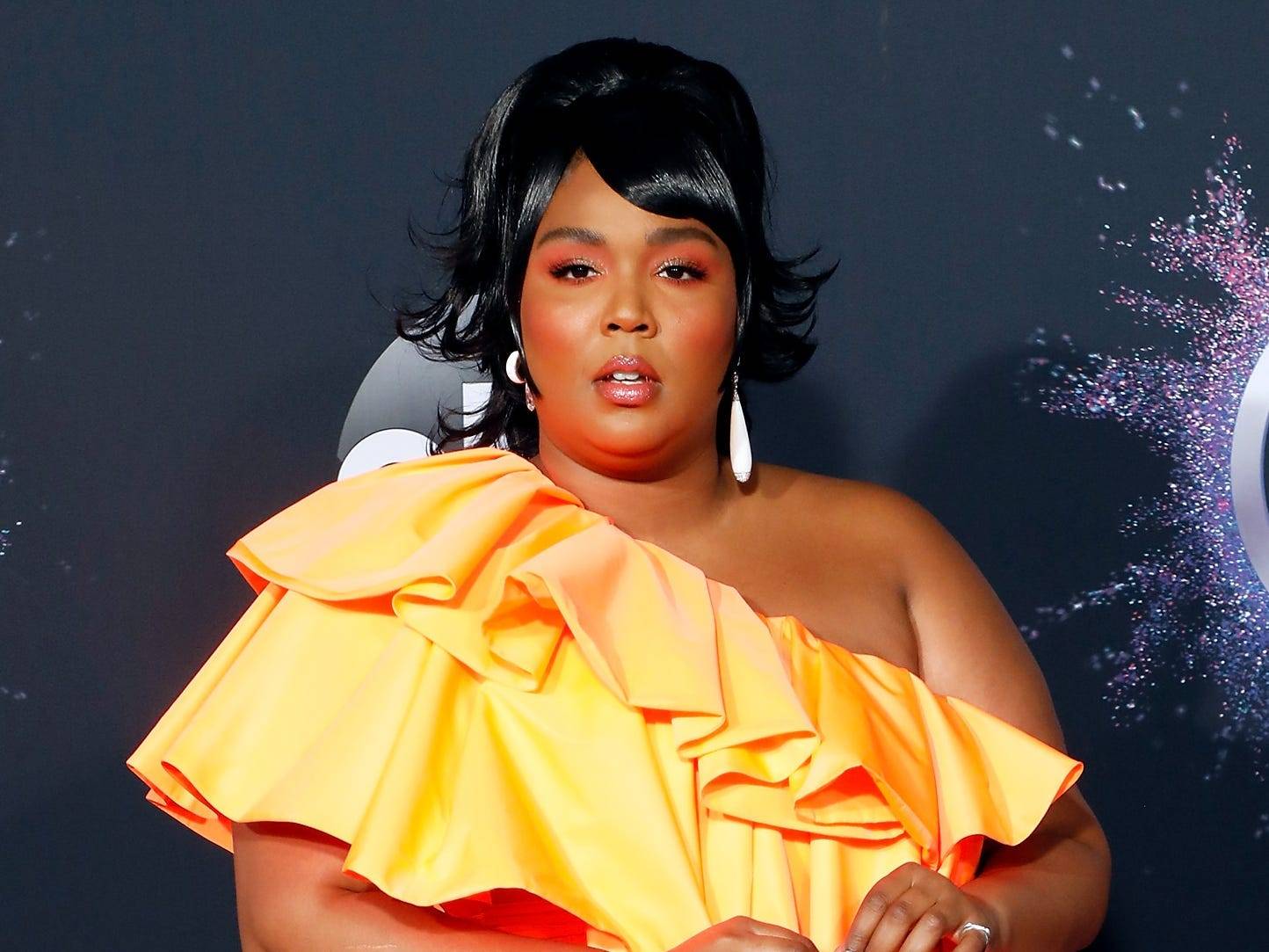 Lizzo posed in a daring American flag jumpsuit that was cut in half to ...
