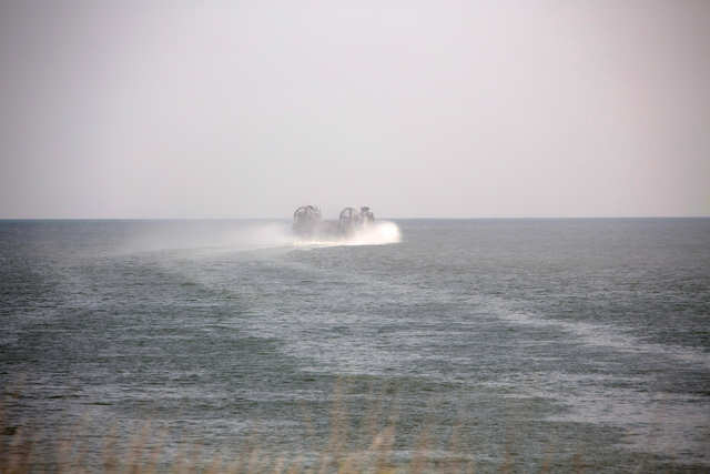 A couple small patrol craft speed past the LCA as it heads in ...