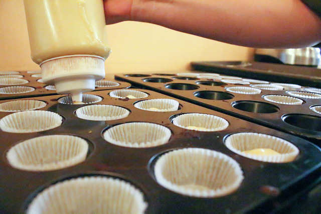 Step Inside The Lower East Side Bakery That Infuses Alcohol Into Its - she pours the batter into a squeeze bottle and rapid fire fills rows of mini